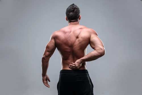Muscular-man-with-back-pain-on-a-gray-background