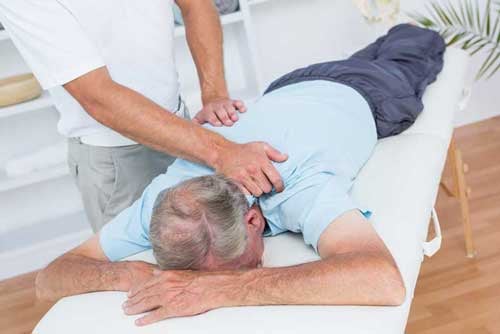 Physiotherapist-doing-neck-massage-to-his-patient-in-medical-office-1-1