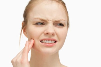 Woman massaging her cheek against white background-1