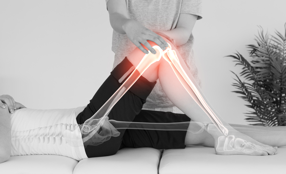 A physical therapist moving a patient's knee